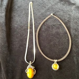 Two sterling silver pendants with yellow stones - price is for both